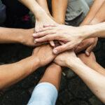 Gruppe von Menschen, die gemeinsam mit Spi United Hands Teamwork aufbauen